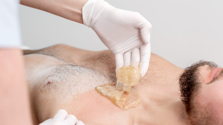 man receiving body waxing