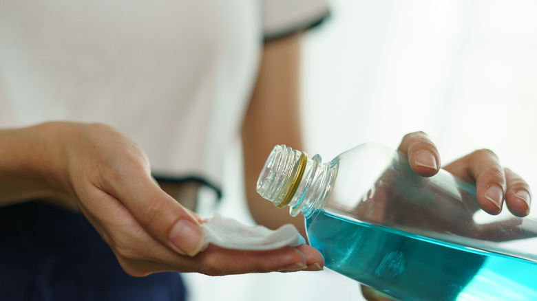 Hand pouring bottle of cleaning fluid