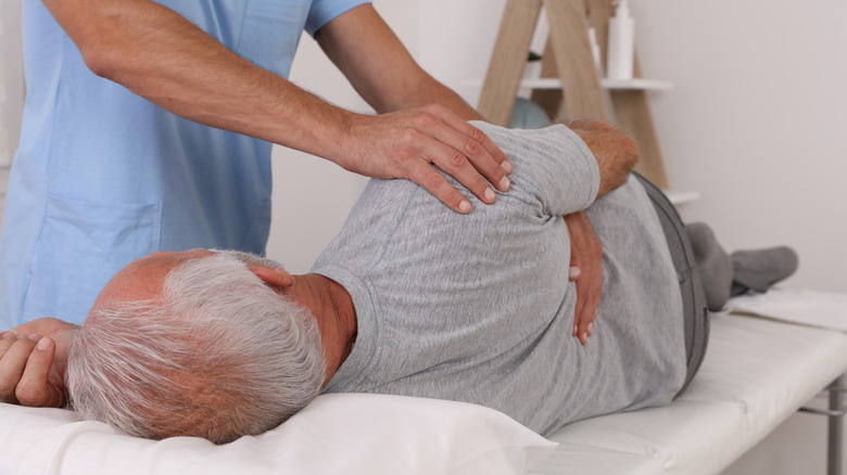 Chiropractor cracking an older gentleman's back