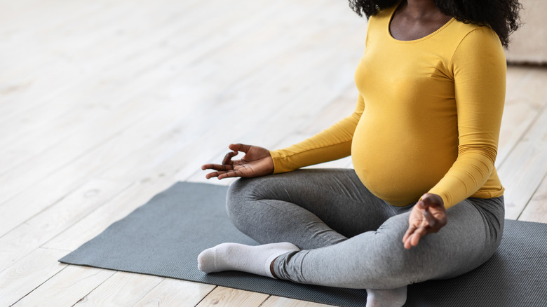 Pregnant woman sitting yoga mat