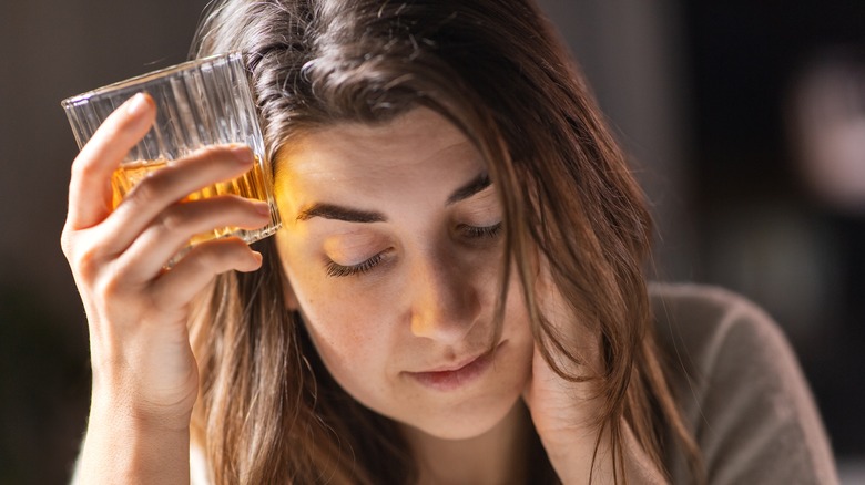 Woman drinking alcohol and looking sad and depressed