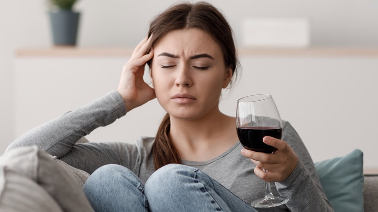 a woman feeling negative effects of combining wine and medication
