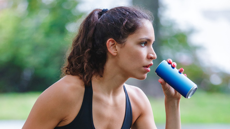 fit woman drinking a can of soda