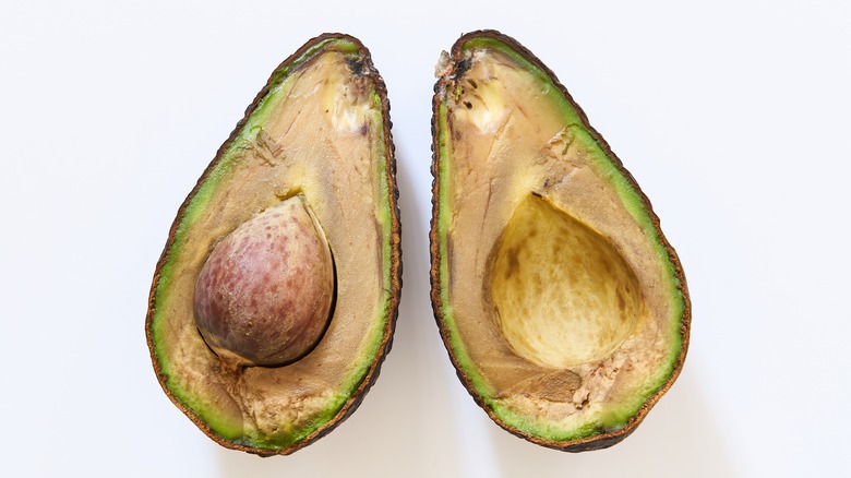 Inside of a browning avocado on white background