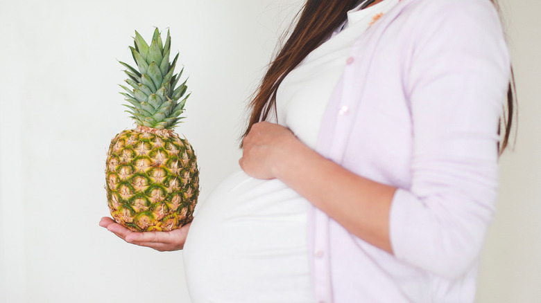 Pregnant woman holding a pineapple