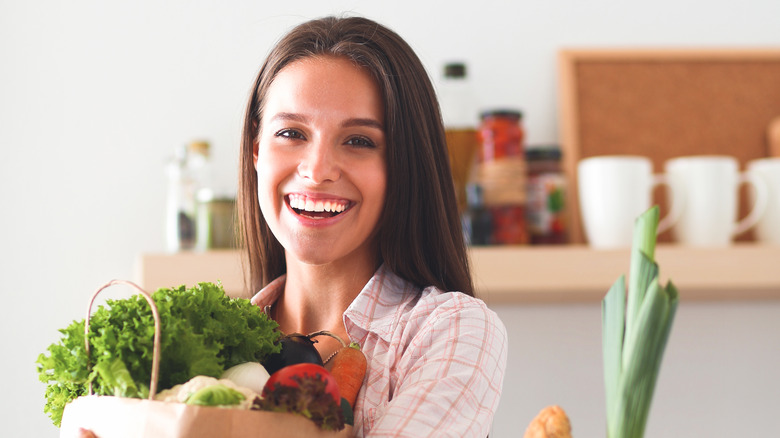 Women holding grocery bag with lettuce