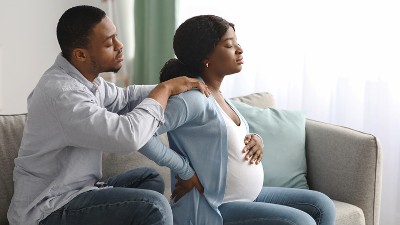 Man gives pregnant woman back massage