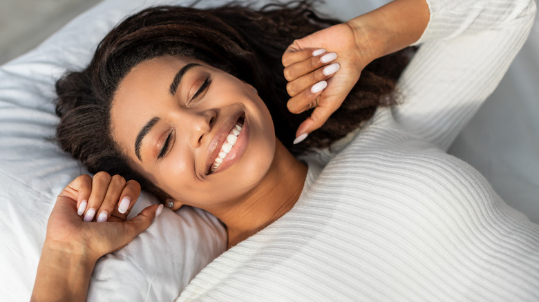 Smiling woman asleep on her back