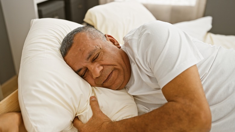 senior man sleeping comfortably in bed