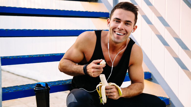 Man eating banana before workout 