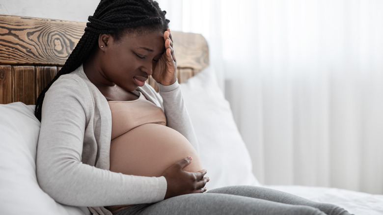 Pregnant woman feeling sick in bed