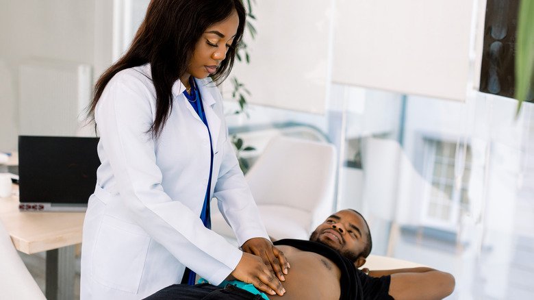 Doctor examining patient's stomach