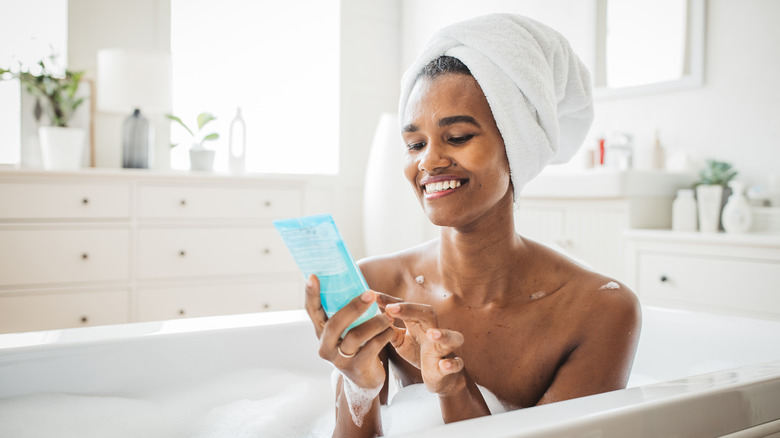 Woman reading body wash label