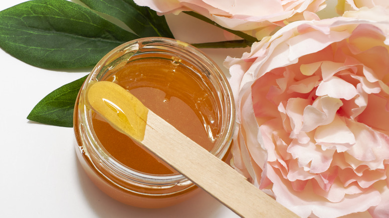 Jar of wax next to flowers