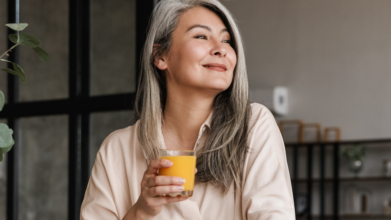 mature woman drinking a glass of juice 