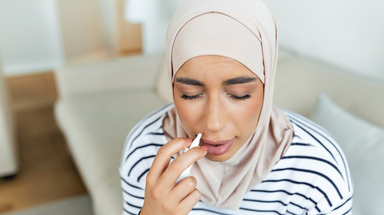 Woman using nasal spray