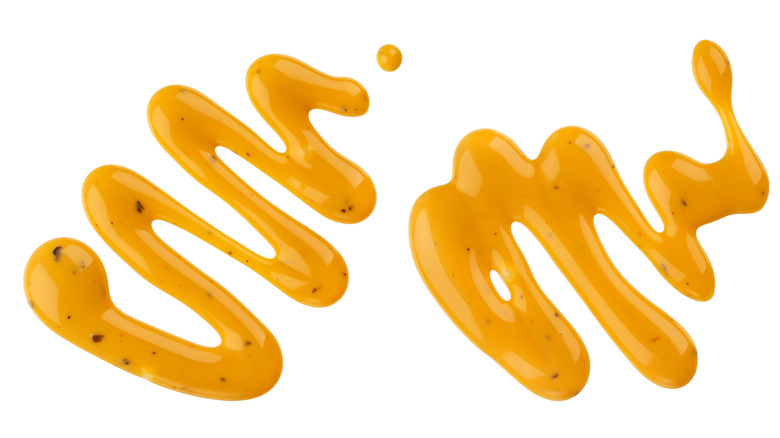 two drizzles of mustard on an isolated white background 