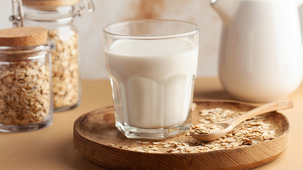 Oat milk in glass with oats