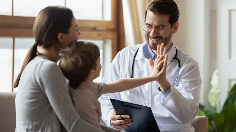 mother and son sitting with doctor