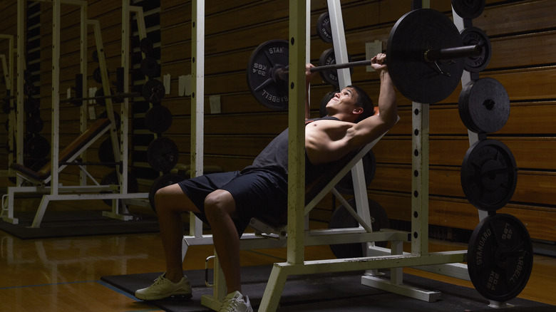 man lifting weights inside gym