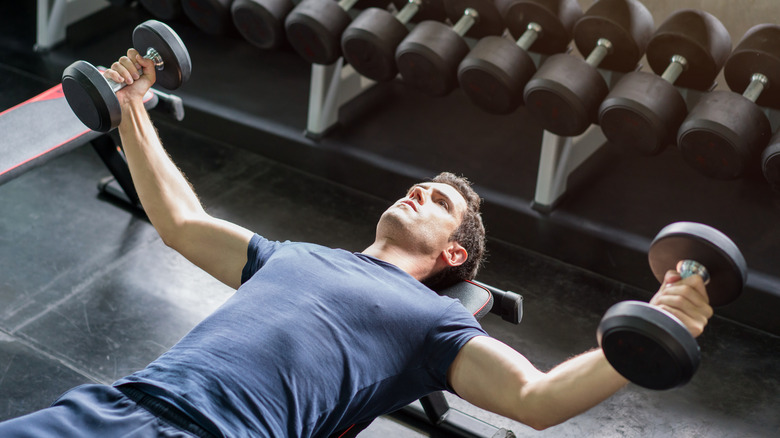 man lifting weights inside gym