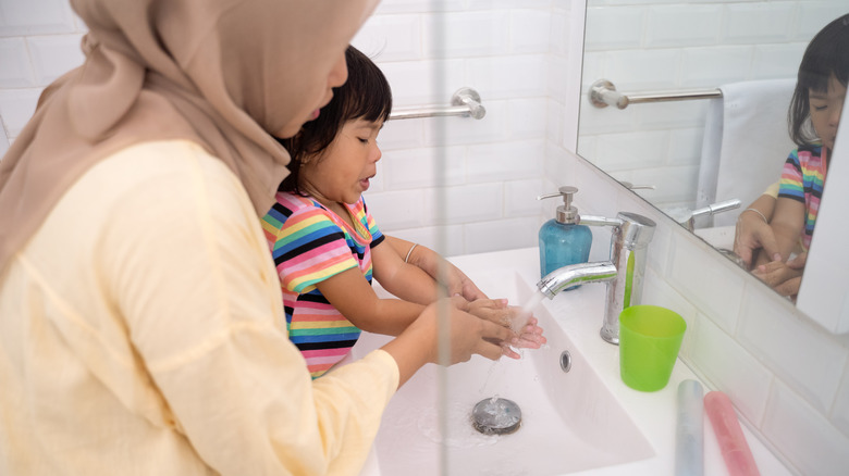 Woman and child washing hands