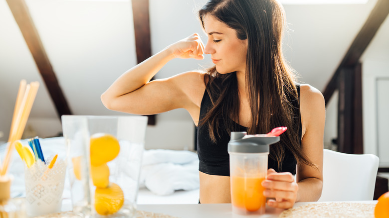 A woman drinks a sports drink after working out