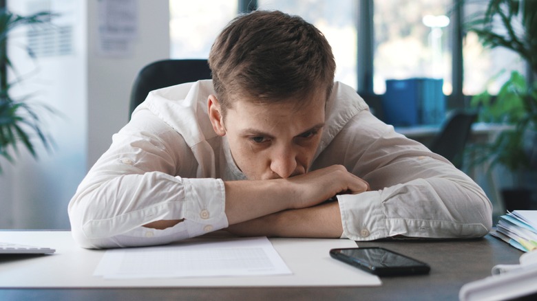 Man with head down at desk