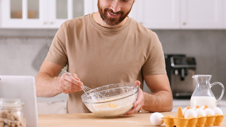 A man iwhisking eggs in a bowl