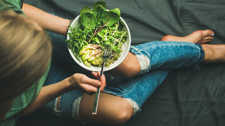 A girl eating spinach salad