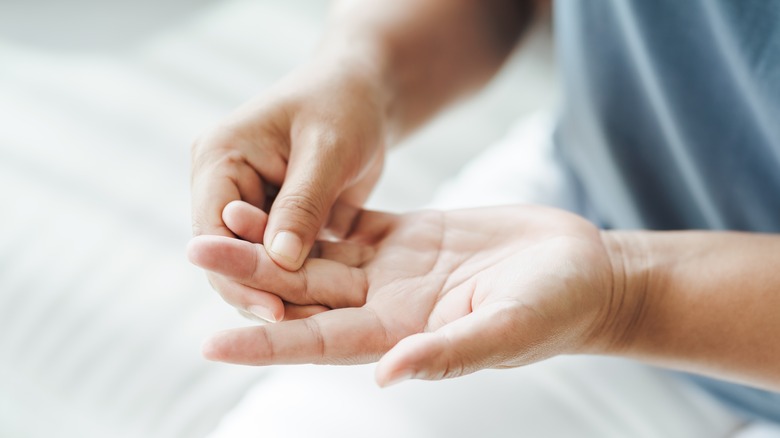 A person holds their hand that has arthritis