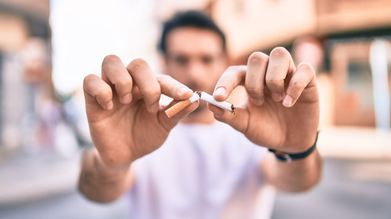 Man breaking a cigarette