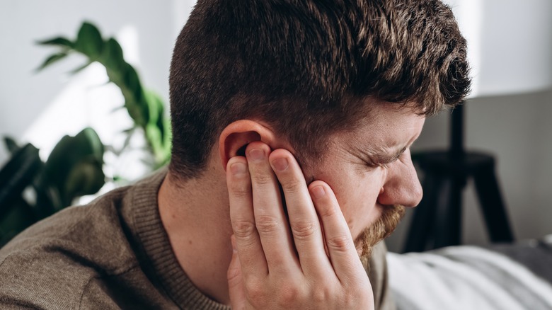 Man holding ear in pain