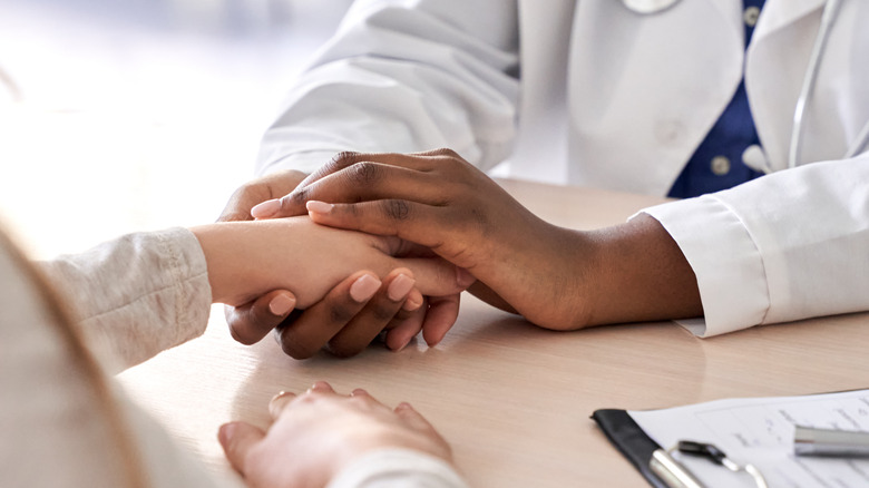 doctor holding patient's hand