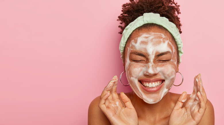 smiling woman washing face