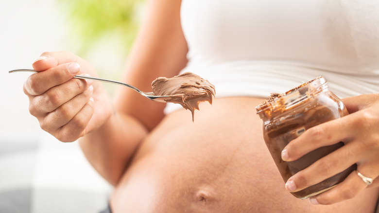 Pregnant woman eating peanut butter