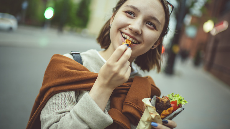 girl eating a wrap with vegetables