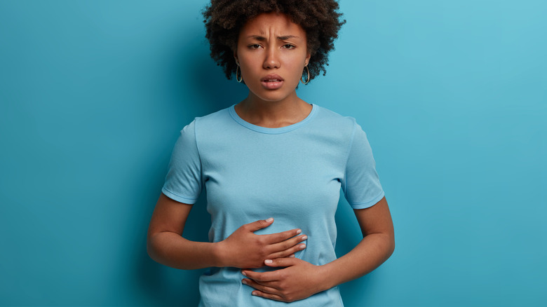a woman grabbing her stomach in pain 