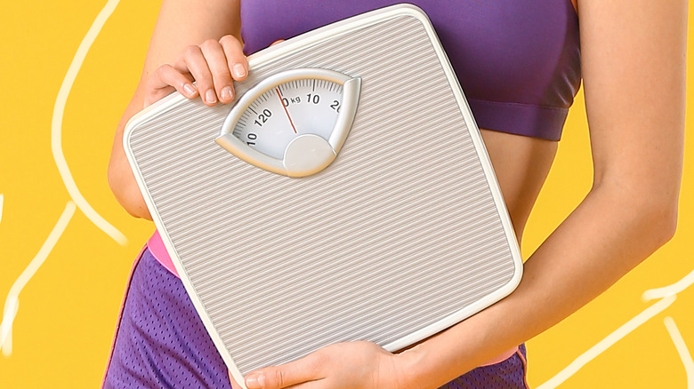 woman holding a scale