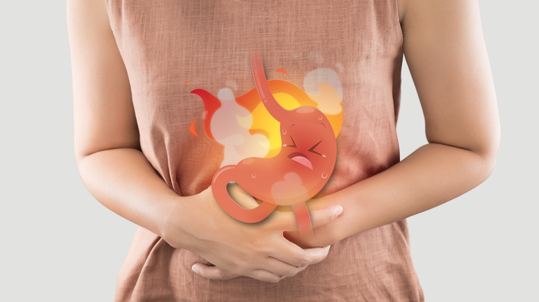 woman grabbing stomach illustrating heartburn