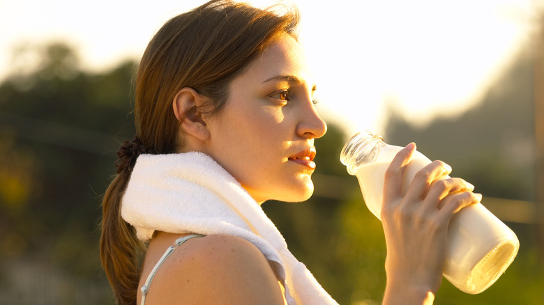 woman drinking a bottle of milk after her workout