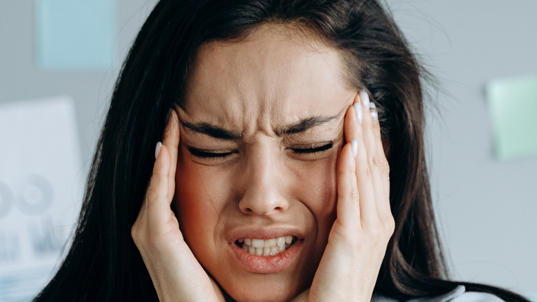 stressed out woman holding her temples