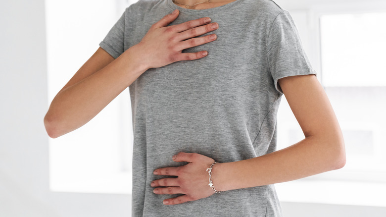 woman's hands on lower abdomen and chest
