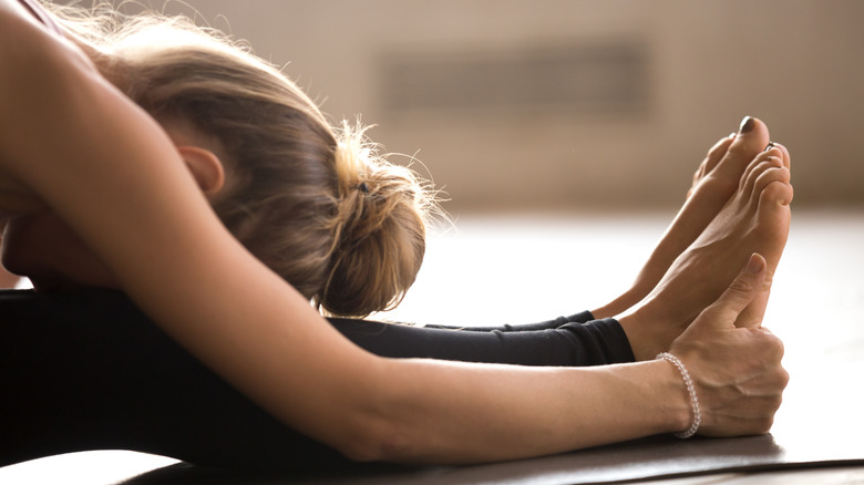 woman touching feet during yoga