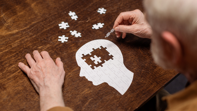 Elderly man doing a puzzle