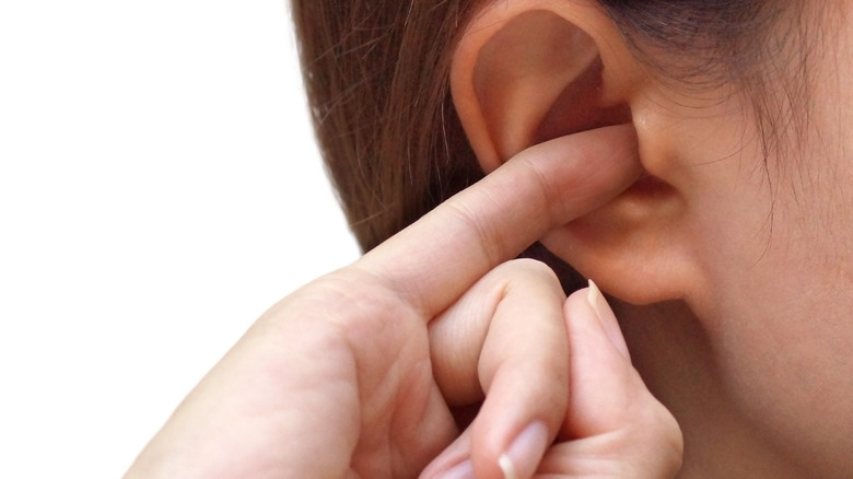 person scratching itchy ear