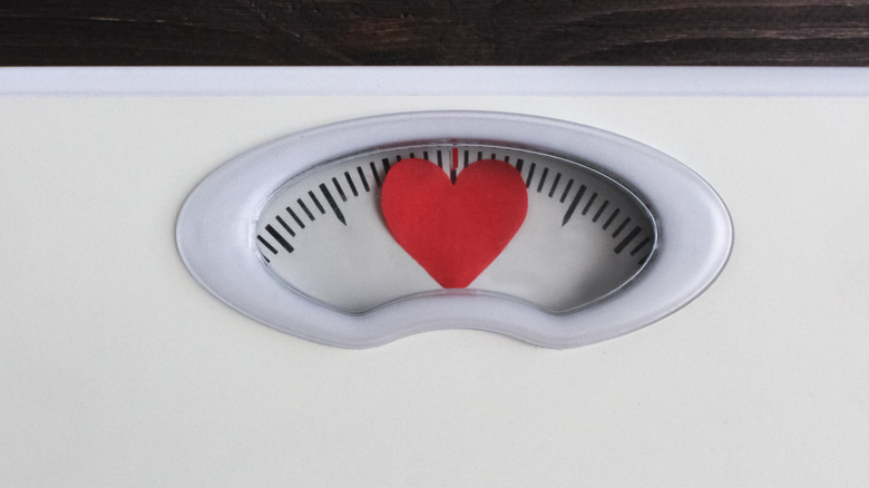 scale with a red heart to portray weight and a healthy heart 