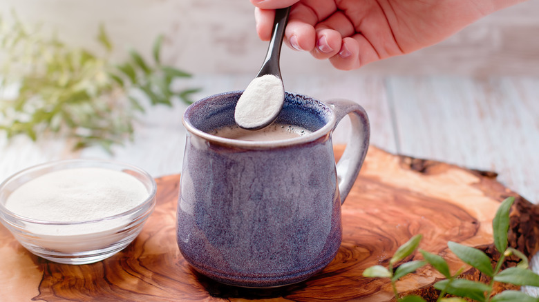 woman adding collagen powder to her coffee