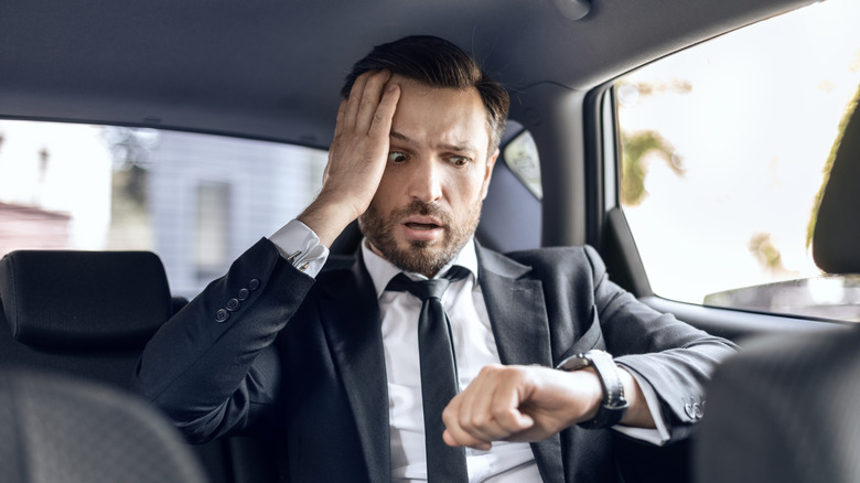 worried man looking at watch 