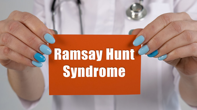 Someone holds a sign that says Ramsay Hunt Syndrome